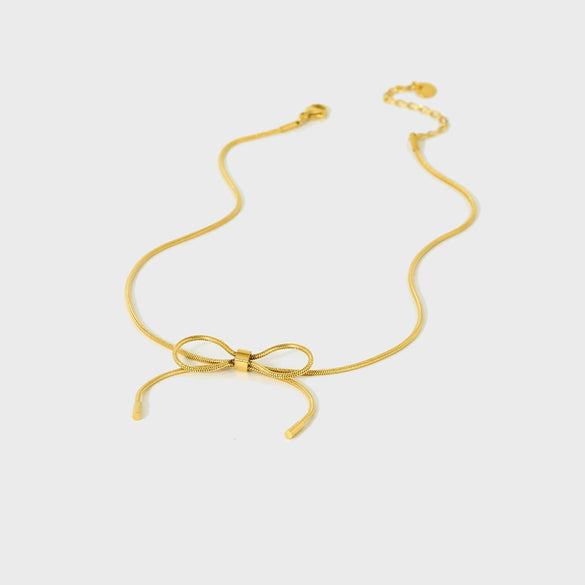 Wholesale Women's Bow Pendant Necklace With Snake Bone Chain In Titanium Steel Electroplated With 18K Gold