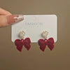 Wholesale Women's Light Luxury Flocking Bow And Heart Zinc Alloy Earrings With Electroplating Treatment