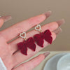 Wholesale Women's Light Luxury Flocking Bow And Heart Zinc Alloy Earrings With Electroplating Treatment