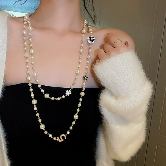 Wholesale Women's Metal And Imitation Pearl Sweater Chain Necklace With Flower Pattern And Light Luxury Style Set With Pearls
