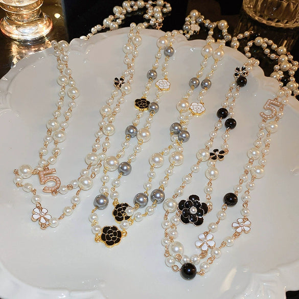 Wholesale Women's Metal And Imitation Pearl Sweater Chain Necklace With Flower Pattern And Light Luxury Style Set With Pearls