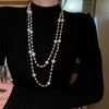 Wholesale Women's Metal And Imitation Pearl Sweater Chain Necklace With Flower Pattern And Light Luxury Style Set With Pearls